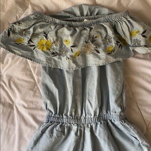 Jean romper with flower design and pockets.